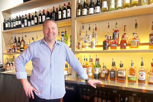 restaurant owner stands in front of bar