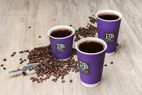 Three purple PJ's Coffee cups with spilled coffee beans and scoop on the floor.