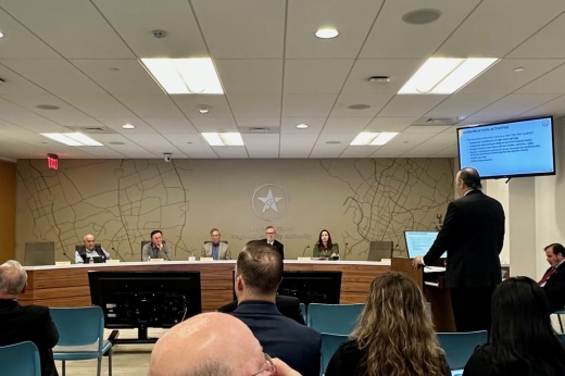 People sitting on a dias and one man presentation is happening.