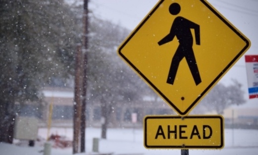 Photo of a pedestrian crossing sign in the snow