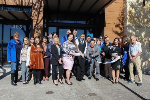 Jesse Ramos, Sunflower Bank’s Retail Branch Manager and Vice President for San Marcos cuts ribbon with his team and community supporters around him. (Amira Van Leeuwen/Community Impact).