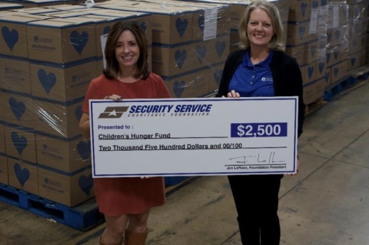 Brandy Ralston-Lint (left), senior vice president of corporate communications for Security Service Federal Credit Union, presents Angie Worth (right), volunteer program coordinator for Children’s Hunger Fund, with a donation for $2,500. (Courtesy Security Service Federal Credit Union)
