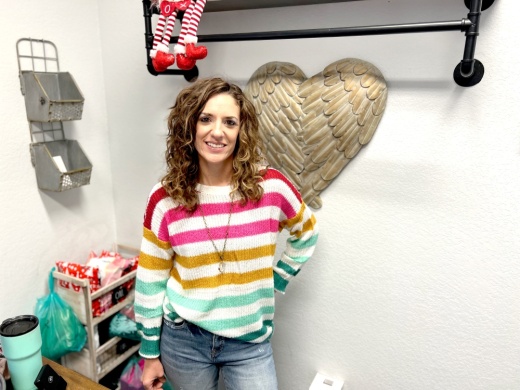 store owner angela huling wears a striped sweater and necklace