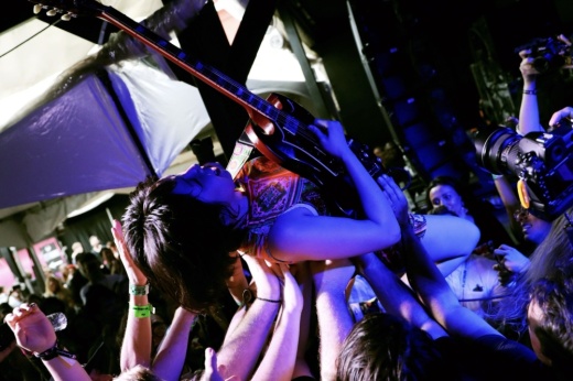 person with guitar crowd surfing