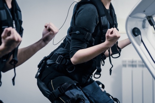 Closeup of two women squatting during EMS workout at gym