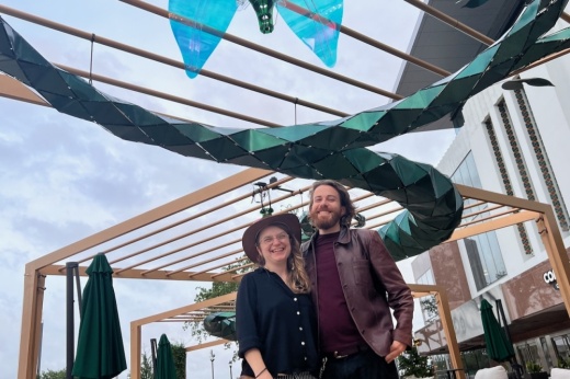 Partners and co-creators of "Efflorescence," the Austin-based artist team consisting of Ilya Pieper and Nathan Kandus from Whiptail Designs, stand next to their art installation at the Ion on March 30. (Melissa Enaje/Community Impact)