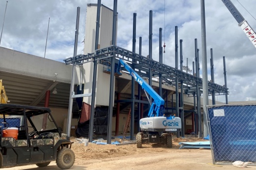 a crane lifts up a mental beam at the stadium