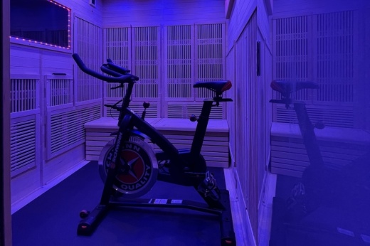 room bathed in purple lighting with an exercise bike