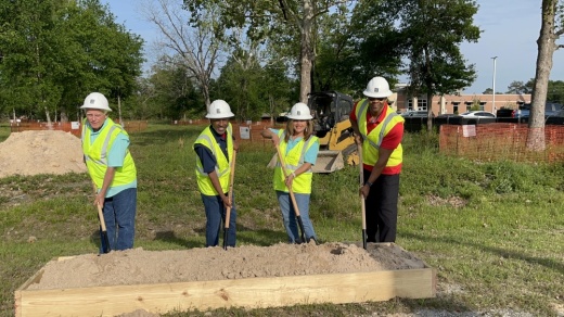 Four people holding shovels during a groundbreaking