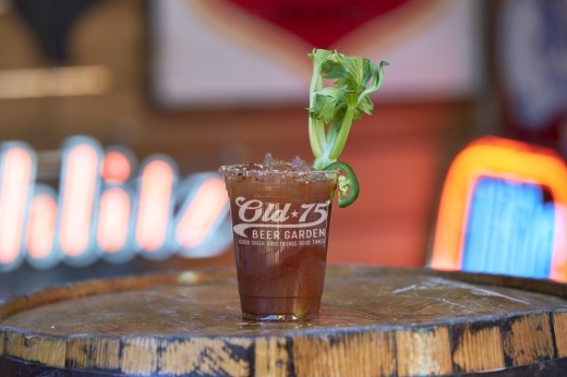 image of a drink on a barrel garnished with celery and a slice of jalapeno