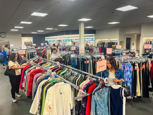 people shop from racks in a consignment store