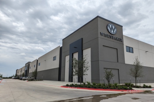 wisenbacker building services building is a large facility painted two different shades of gray with the wisenbacker logo on the side