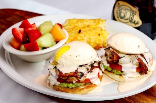 eggs benedict with hashbrowns and fruit on the side