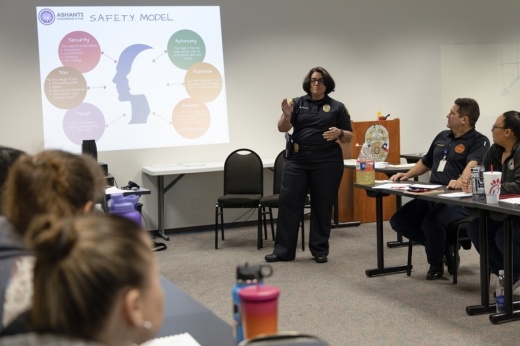 Female officer teaching group of police officers with powerpoint presentation