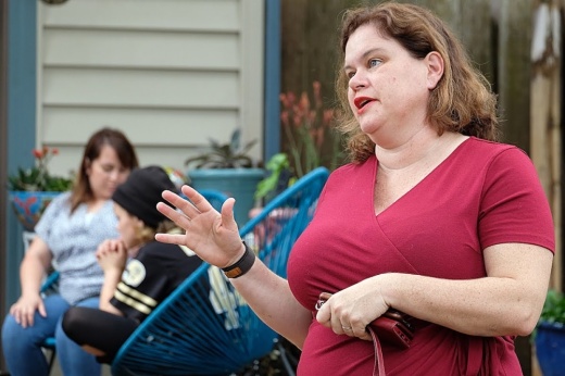 Nicki Hendrix wearing a red shirt in the foreground. A child in a black beanie and a therapist in the background.