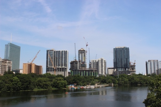 Rainey Street seen over the river with several high rises and cranes.