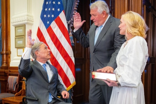 Gov. Greg Abbott (left) swears in John Scott (center) who takes the oath of office using a bible held by his wife (right).