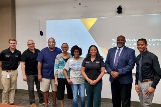 A group of people standing in front of power point presentation