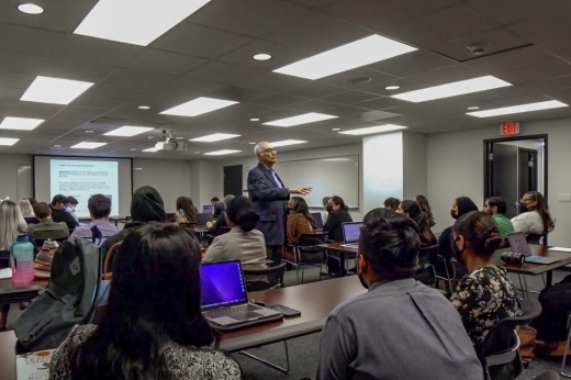 Healthcare administration professor teaching students in a classroom.