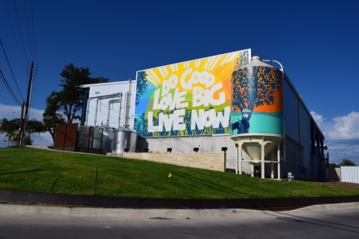 A colorful mural on the side of the building reads "Do good, love big, live now"