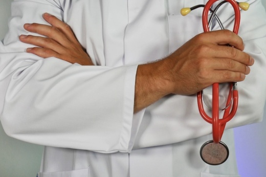 A doctor wearing a white coat and holding a stethoscope.
