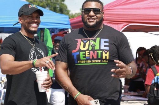 two men pose in front of tents
