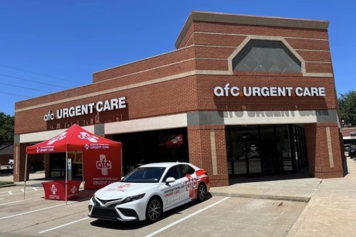 Brick building with medical tent and car parked in front