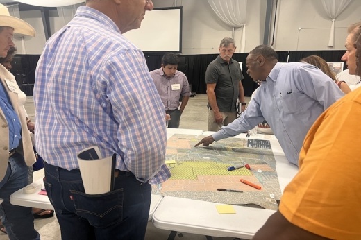 People pointing at map and construction plans