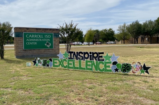 a sign that reads Inspire Excellence is set on holders in grass