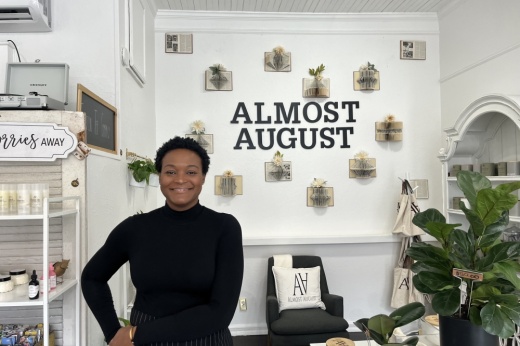 Picture shows owner standing in front of the almost august sign.