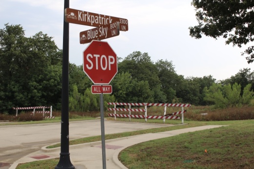 Picture of a street-stop sign and a street that dead ends with road barriers