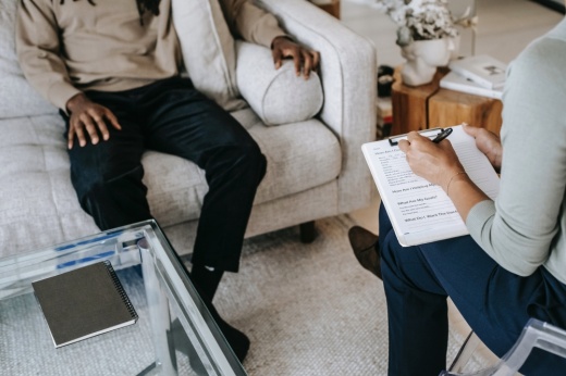 a female physicians writes on a note pad during a session