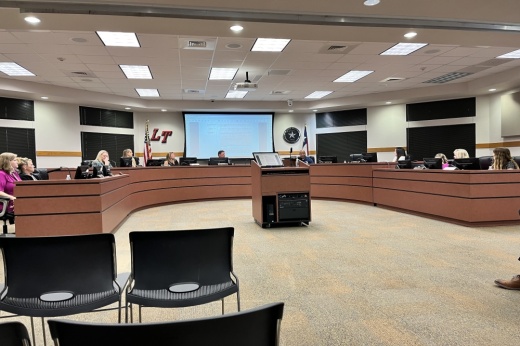 interior photo of a school board room with trustees sitting behind the dais