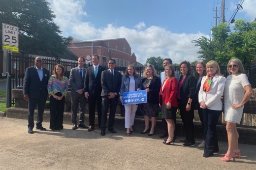 U.S. Rep. Lizzie Fletcher, D-Houston (center) is flanked by officials with Harris County, the city of West University Place, the city of Southside Place and state leaders. The group gathered at Southside Place City Hall on June 28 to announce critical funding that will allow flood control work on Poor Farm Ditch to move forward. (Shawn Arrajj/Community Impact)