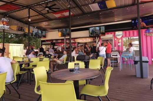 People sit and enjoy beverages on a patio at Bodhi's Bodacious Hideaway