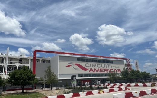 An outside view of the COTA gate in the daytime with clouds in the blue sky