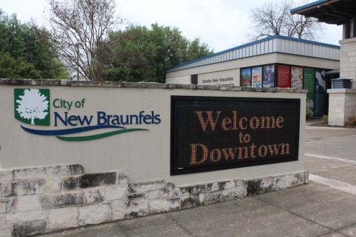 wall with signage that says city of new braunfels welcome to downtown