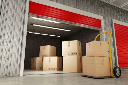 Boxes on a dolly in front of a storage unit with boxes in it