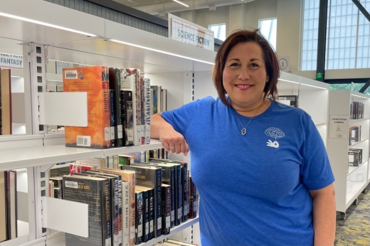 sandy tutwiler leans against a book shelf