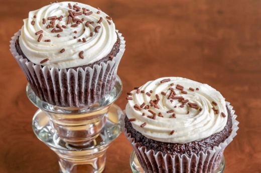 two chocolate cupcakes on a stand
