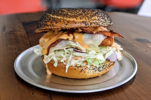 bagel sandwich with a fried chicken cutlet, coleslaw, bacon, mozzarella cheese and Russian dressing