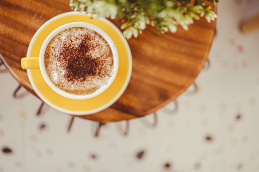 yellow coffee mugs on wooden table in cafe