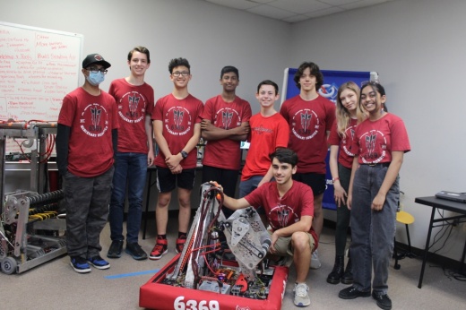 Students from Mercenary Robotics standing with their robot