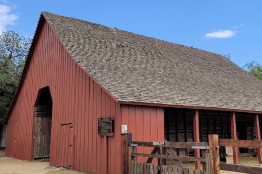 a red barn with a black shingle roof