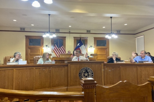 Commissioners raise their hands to vote