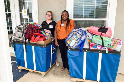 two workers with school supplies