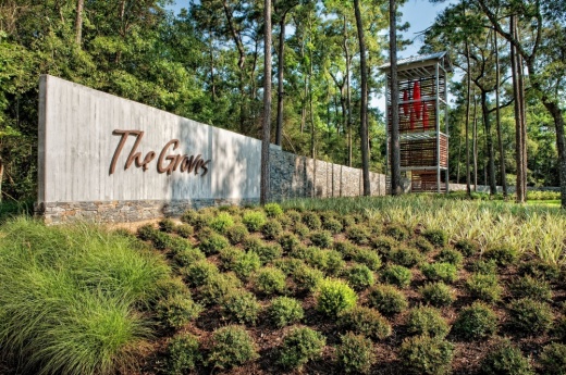 A photo of the sign for The Groves community surrounded by nature