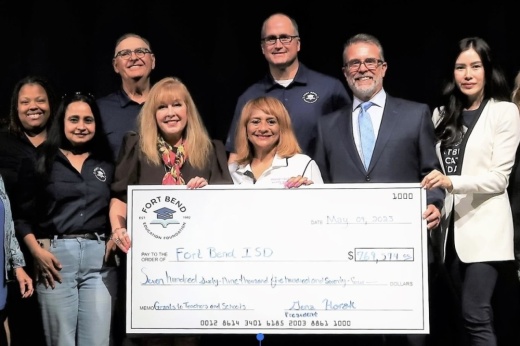 A group of people holding a large nonprofit check for charity