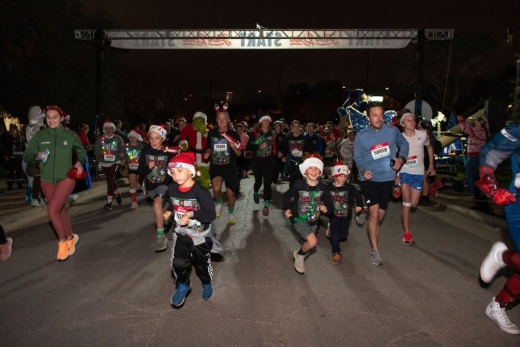 A group of children and adults race through the fun run during a previous year dressed in holiday attire.