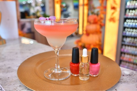 This image shows a cocktail and nail polish on a platter at Milano Nail Spa.